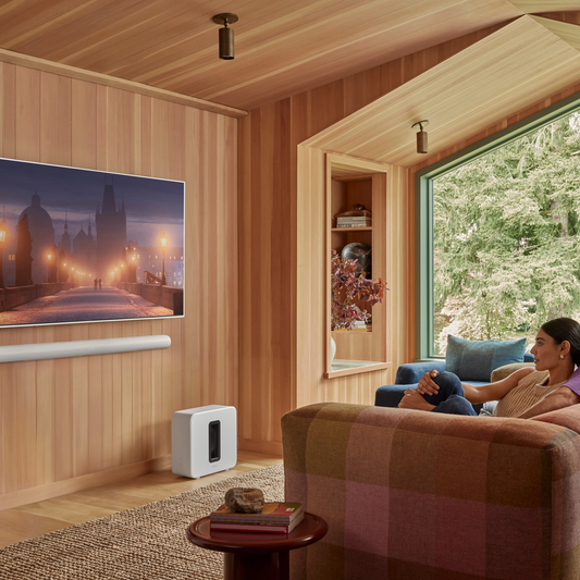 Couple watching movie with Sonos Ace Ultra and Sonos Sub 4 in Family living room